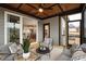 This screened porch features lots of seating, wood paneled ceiling, and slider access to the home's interior at 100 Firefly Ln, Louisburg, NC 27549