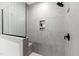 Modern shower featuring light gray tile, black hardware, a glass door, and a recessed niche at 100 Firefly Ln, Louisburg, NC 27549