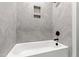 Close-up of the shower/bathtub featuring tile surround and a handheld shower fixture at 100 Firefly Ln, Louisburg, NC 27549