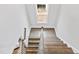 Staircase with hardwood treads and white risers leading up to a window at the top landing at 100 Firefly Ln, Louisburg, NC 27549