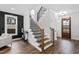 Staircase with wooden treads, black railings, and a view of the front door at 100 Firefly Ln, Louisburg, NC 27549