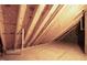 View of an unfinished attic space with exposed wooden beams, OSB subflooring, and a white support beam at 100 Firefly Ln, Louisburg, NC 27549
