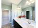 Well-lit bathroom featuring a dual sink vanity, a large mirror, and neutral green-toned walls at 21 Oakbridge Way, Pikeville, NC 27863