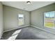 Sunlit bedroom with new carpet, showcasing bright views from double windows and freshly painted walls at 21 Oakbridge Way, Pikeville, NC 27863