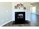 Living room fireplace with white mantle and black hearth showcasing wood flooring at 21 Oakbridge Way, Pikeville, NC 27863
