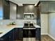 Modern kitchen with sleek black cabinets, stainless steel appliances, and stylish backsplash at 21 Oakbridge Way, Pikeville, NC 27863