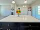 A modern kitchen island featuring a white countertop and black cabinets with views to the fireplace and sliding glass doors at 21 Oakbridge Way, Pikeville, NC 27863
