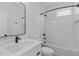 Modern bathroom showcasing a sleek vanity, framed mirror, and tiled shower-tub combo with black fixtures and bright lighting at 227 Woodsborough Pl, Raleigh, NC 27601