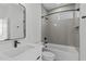 Modern bathroom with sleek fixtures, gray tile, and a combined tub and shower at 227 Woodsborough Pl, Raleigh, NC 27601