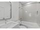 Well-lit bathroom features gray tiles, shower-tub, modern vanity and fixtures at 227 Woodsborough Pl, Raleigh, NC 27601