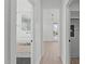 Bright hallway with hardwood floors leading to a modern bathroom with sleek fixtures and stylish design at 227 Woodsborough Pl, Raleigh, NC 27601