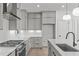 Well-lit kitchen featuring sleek gray cabinetry, stainless steel appliances, and a stylish backsplash at 227 Woodsborough Pl, Raleigh, NC 27601