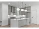 Bright kitchen with gray cabinets, modern lighting, white countertops, and a large island at 227 Woodsborough Pl, Raleigh, NC 27601