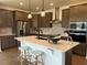 Modern kitchen features quartz countertops, stainless steel appliances, and a breakfast bar with seating at 235 Chestnut Oak Ln, Lillington, NC 27546
