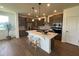 Modern kitchen features island with breakfast bar, stainless steel appliances, and stylish pendant lighting at 235 Chestnut Oak Ln, Lillington, NC 27546