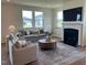 Bright living room featuring fireplace, plush seating, large windows offering plenty of natural light at 235 Chestnut Oak Ln, Lillington, NC 27546