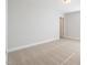 A bright bedroom with neutral walls, carpeted floor, and door to the hall at 103 W Star Foal Ln, Wendell, NC 27591