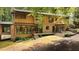 Back exterior showcasing a two-story home with a large deck and wooded setting at 4416 Arrowhead Trl, Hillsborough, NC 27278