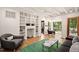 Cozy living room with hardwood floors, built-in shelving, and access to a deck at 4416 Arrowhead Trl, Hillsborough, NC 27278