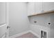 Convenient laundry room with bright white cabinets, tile flooring, and modern utility connections for laundry appliances at 75 E Star Foal Ln, Wendell, NC 27591