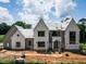 New construction home featuring multiple gables, large windows, and a modern design under a cloudy blue sky at 9105 Overlook Crest Dr, Wake Forest, NC 27587