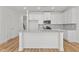 Modern kitchen features white cabinets, granite countertops, stainless steel appliances, and hardwood floors at 953 Alma Railway Dr, Wake Forest, NC 27587