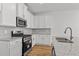 Modern kitchen features white cabinets, granite countertops, stainless steel appliances, and hardwood floors at 953 Alma Railway Dr, Wake Forest, NC 27587