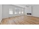 Spacious living room with a modern fireplace, hardwood floors, ceiling fan, and natural light from large windows at 953 Alma Railway Dr, Wake Forest, NC 27587