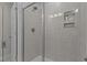 Contemporary shower with glass door, white tile walls, and built-in shelves for toiletries at 959 Alma Railway Dr, Wake Forest, NC 27587