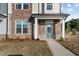 A close-up of a townhome entrance, showcasing stone detail and a teal front door at 959 Alma Railway Dr, Wake Forest, NC 27587