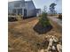 Landscaped backyard featuring newly installed plants, mulch and a driveway near a home at 649 Riverwood Dr, Clayton, NC 27527