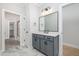 Modern bathroom featuring a gray vanity with quartz countertop and sleek fixtures at 649 Riverwood Dr, Clayton, NC 27527