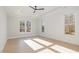Sunlit bedroom featuring hardwood floors, neutral walls, tray ceiling, and multiple windows at 649 Riverwood Dr, Clayton, NC 27527