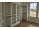 Walk-in closet with built-in shelving, wooden rods, and natural light from the window at 649 Riverwood Dr, Clayton, NC 27527