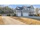 Angled view of a gray two-story home with a three-car garage, long driveway and well maintained lawn at 649 Riverwood Dr, Clayton, NC 27527