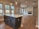 Open kitchen featuring a gray island, stainless steel appliances and hardwood floors and a large opening to a living room at 649 Riverwood Dr, Clayton, NC 27527