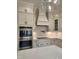 Modern kitchen with stainless steel appliances, white cabinets, and a stylish range hood at 649 Riverwood Dr, Clayton, NC 27527