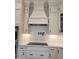 Elegant kitchen with white cabinets, stainless steel oven, range hood, and modern countertops at 649 Riverwood Dr, Clayton, NC 27527