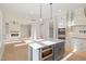 Open kitchen with gray island, stainless appliances, view into living room, and hardwood floors at 649 Riverwood Dr, Clayton, NC 27527