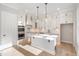 Kitchen boasts white cabinetry, stainless steel appliances, a center island, and modern lighting at 649 Riverwood Dr, Clayton, NC 27527