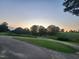 Picturesque sunset view of the golf course at dusk, with trees silhouetted against the sky at 649 Riverwood Dr, Clayton, NC 27527