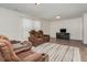 Bright living room with brown leather sofas and wood floors at 71 Nolan Ct, Lillington, NC 27546