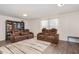 Spacious living room featuring brown leather sofas and wood floors at 71 Nolan Ct, Lillington, NC 27546