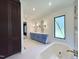 Contemporary bathroom featuring a soaking tub, a double sink vanity, and designer lighting fixtures at 7208 Tanbark Way, Raleigh, NC 27615