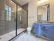 Contemporary bathroom featuring a gray tiled shower with a glass door, toilet and large mirror at 7208 Tanbark Way, Raleigh, NC 27615