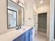 Bright bathroom featuring a marble countertop, a large mirror with black trim, and a walk-in closet with shelving at 7208 Tanbark Way, Raleigh, NC 27615