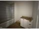 Bathroom featuring a tub with tiled walls and a vanity with white cabinets at 7208 Tanbark Way, Raleigh, NC 27615
