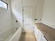 Bathroom showcasing a tub, white tiled walls, and a vanity with hardware at 7208 Tanbark Way, Raleigh, NC 27615