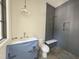Modern bathroom with gray tile shower and white vanity with elegant lighting at 7208 Tanbark Way, Raleigh, NC 27615