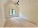 Spacious bedroom with high vaulted ceilings, neutral walls, and a black-framed window at 7208 Tanbark Way, Raleigh, NC 27615